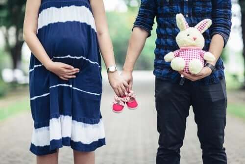 孕婦和男人牽手和嬰兒鞋
